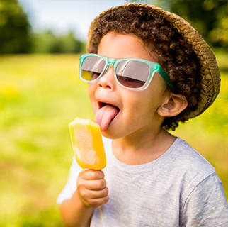 Two-year-old child outside, enjoying ice cream.